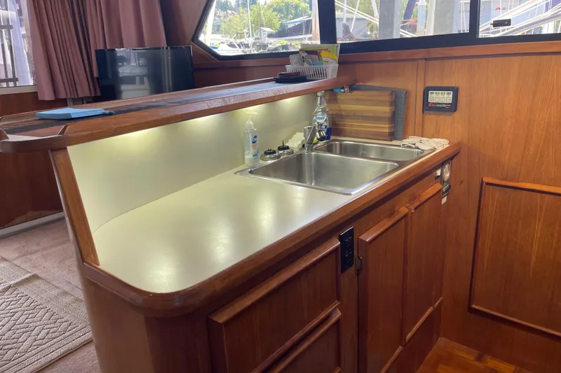  Yacht Photos Pics 1988 Chris-Craft 392 Sport Fish yacht interior with wooden cabinetry and sink area.