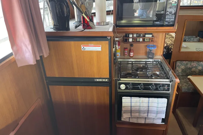  Yacht Photos Pics 1988 Chris-Craft 392 Sport Fish kitchen with stove, fridge, and microwave.