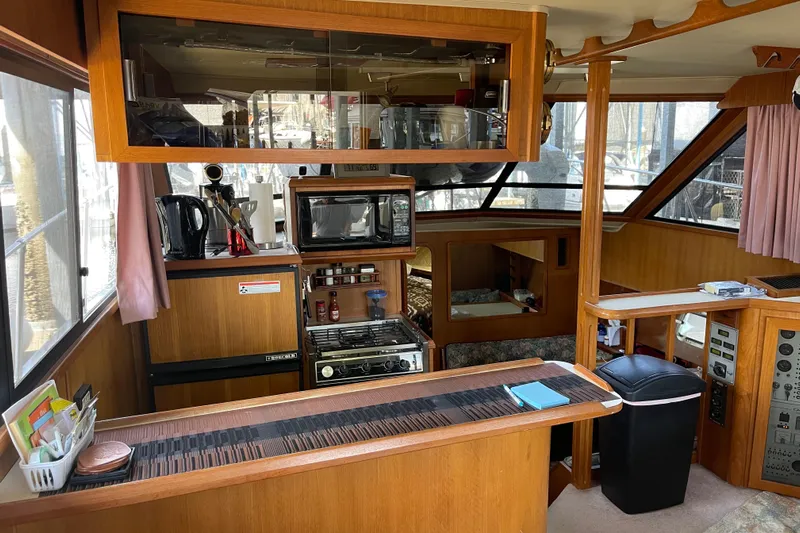  Yacht Photos Pics 1988 Chris-Craft 392 Sport Fish interior with kitchen, appliances, and wood paneling.