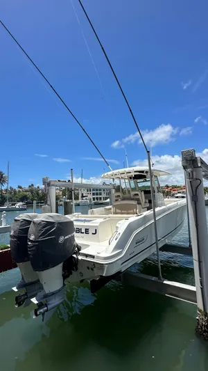  Yacht Photos Pics 2017 Boston Whaler 330 Outrage boat on lift, sunny marina background.