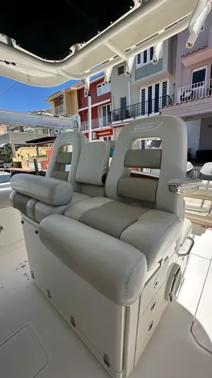  Yacht Photos Pics Luxury seating on 2017 Boston Whaler 330 Outrage boat, docked near colorful buildings.