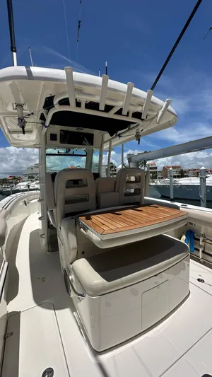  Yacht Photos Pics 2017 Boston Whaler 330 Outrage boat with seating and table, docked under clear skies.