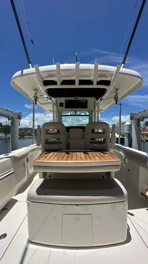  Yacht Photos Pics 2017 Boston Whaler 330 Outrage boat interior with seating and canopy under clear blue sky.