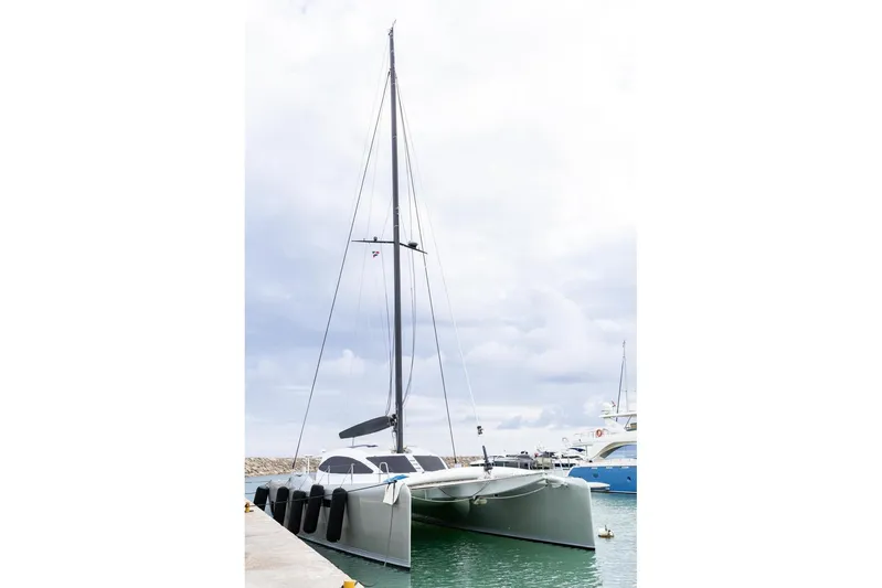 Katari Yacht Photos Pics 2018 Tag 60 catamaran docked in a marina under cloudy skies.