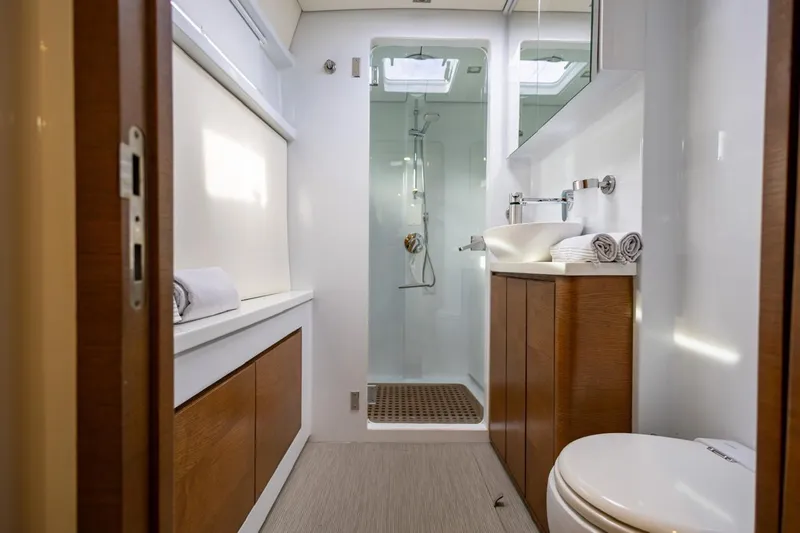 Katari Yacht Photos Pics Modern yacht bathroom with wooden cabinets, glass shower, and sleek fixtures, Tag 60 model, 2018.
