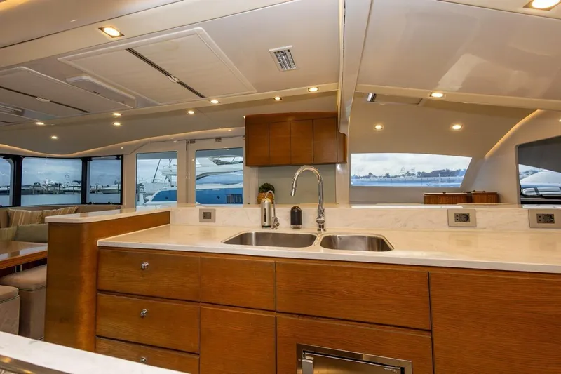 Katari Yacht Photos Pics Luxurious yacht interior with modern kitchen, featuring wooden cabinets and marble countertops, Tag 60, 2018.