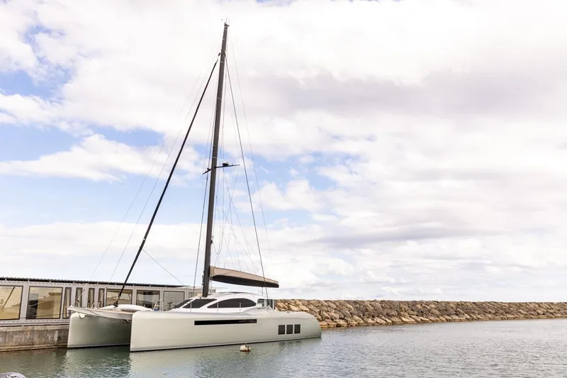 Katari Yacht Photos Pics Modern Tag 60 catamaran docked at marina, 2018 model, under cloudy sky.