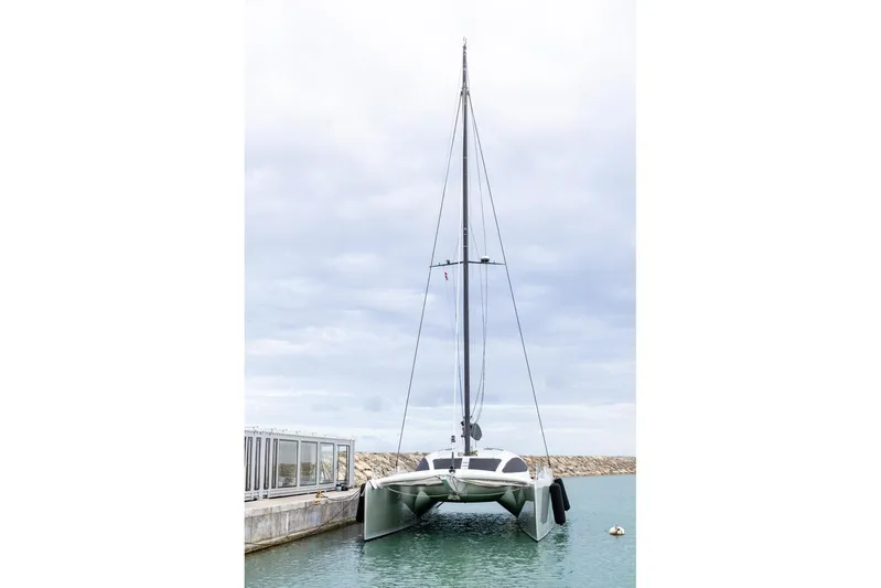 Katari Yacht Photos Pics 2018 Tag 60 catamaran docked in a marina under cloudy skies.