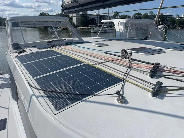 Honey Ryder Yacht Photos Pics 2022 HH Catamarans 50 with solar panels on deck, docked by the water.