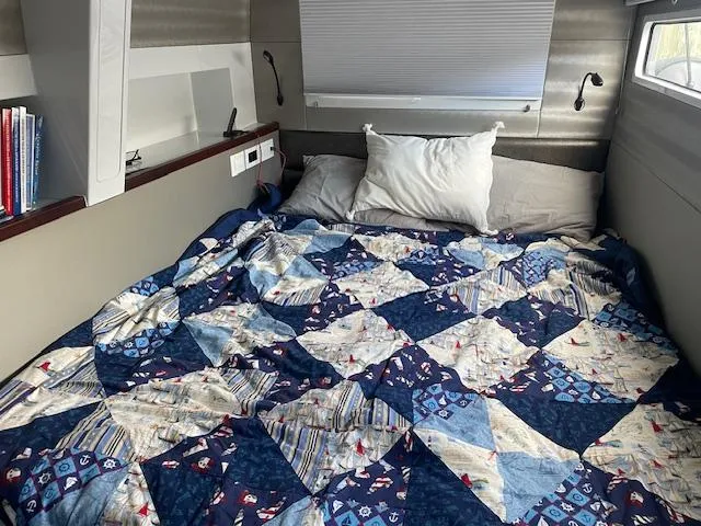 Honey Ryder Yacht Photos Pics Cozy cabin bed in 2022 HH Catamarans 50, featuring a colorful patchwork quilt.
