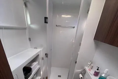 Honey Ryder Yacht Photos Pics Modern bathroom interior of 2022 HH Catamarans 50, featuring sleek design and storage.