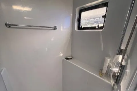 Honey Ryder Yacht Photos Pics Modern bathroom interior of 2022 HH Catamarans 50 with window and shower.