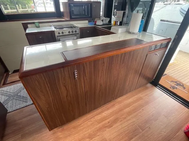 Honey Ryder Yacht Photos Pics Modern kitchen interior of 2022 HH Catamarans 50, featuring wood cabinetry and sleek countertops.