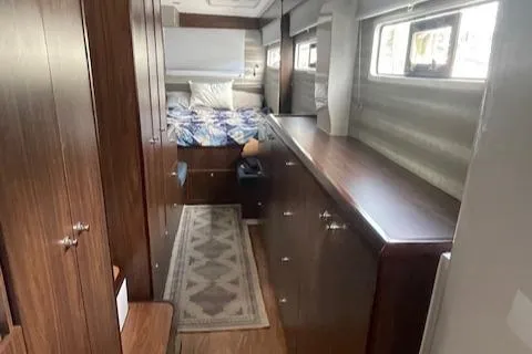 Honey Ryder Yacht Photos Pics Interior of 2022 HH Catamarans 50, featuring a cozy bedroom with wooden cabinetry.