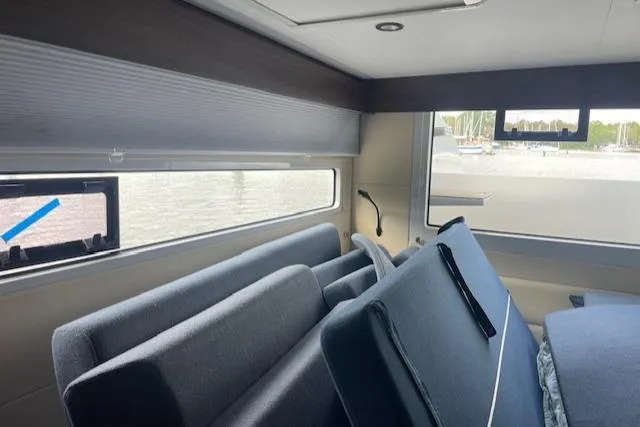 Honey Ryder Yacht Photos Pics Interior of 2022 HH Catamarans 50, featuring modern seating and large windows with marina view.