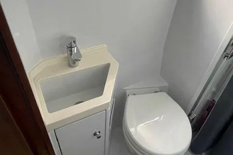 Honey Ryder Yacht Photos Pics Compact bathroom in 2022 HH Catamarans 50, featuring a modern sink and toilet.