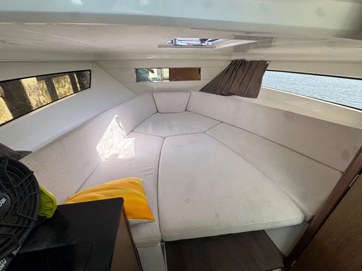  Yacht Photos Pics Cozy interior cabin of 2020 Jeanneau Leader 9.0 WA with beige seating and windows.