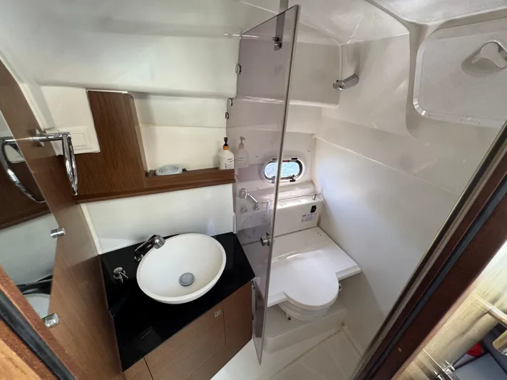  Yacht Photos Pics 2020 Jeanneau Leader 9.0 WA bathroom with sink, toilet, and porthole window.