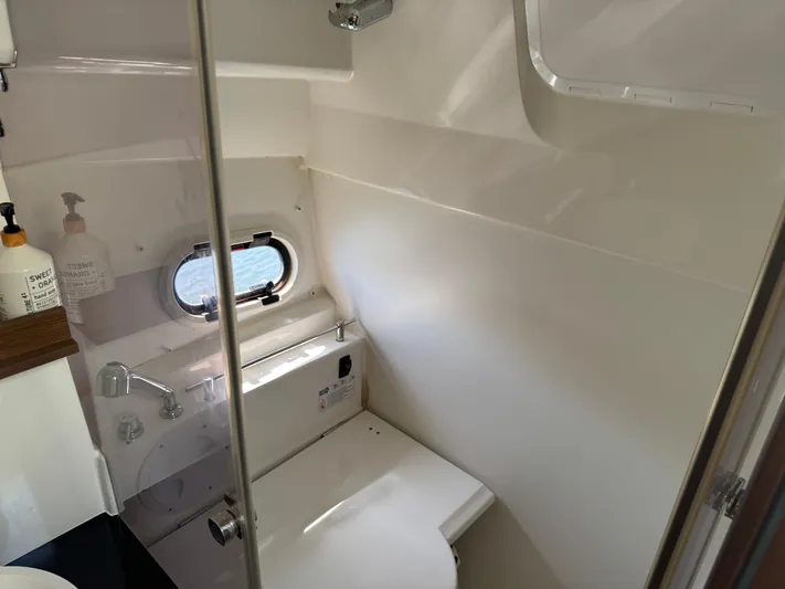  Yacht Photos Pics Compact bathroom in 2020 Jeanneau Leader 9.0 WA boat with window and modern fixtures.