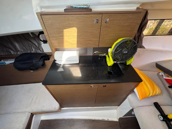  Yacht Photos Pics Interior of 2020 Jeanneau Leader 9.0 WA boat with compact kitchenette and seating area.