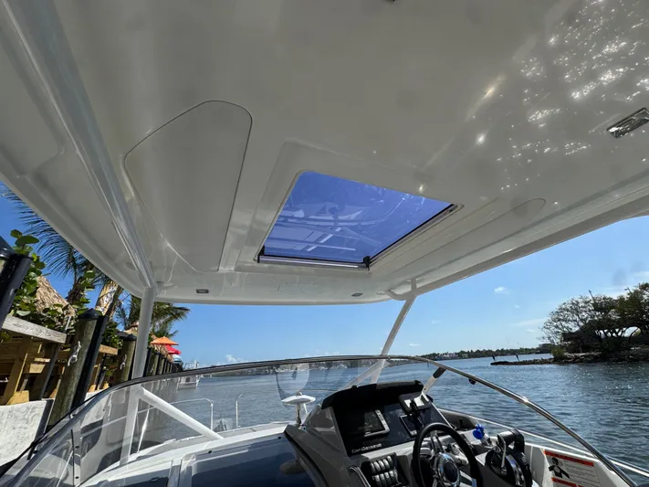  Yacht Photos Pics 2020 Jeanneau Leader 9.0 WA boat interior with sunroof, steering wheel, and water view.