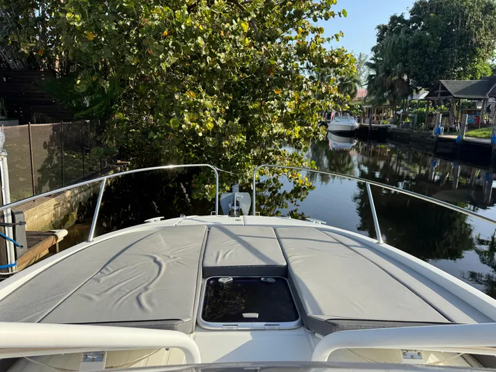  Yacht Photos Pics 2020 Jeanneau Leader 9.0 WA boat on a tranquil canal, surrounded by lush greenery.