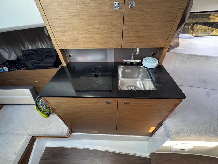  Yacht Photos Pics Compact kitchen area in a 2020 Jeanneau Leader 9.0 WA boat with sink and storage.