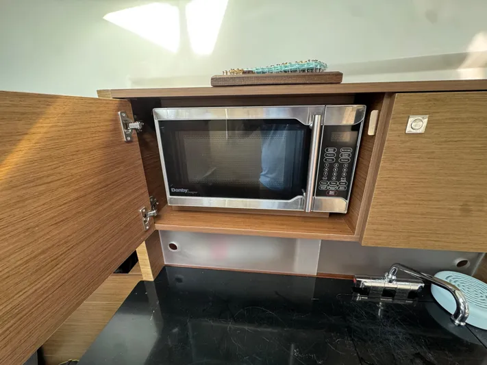  Yacht Photos Pics Microwave in Jeanneau Leader 9.0 WA 2020 boat kitchen, with wooden cabinetry and modern design.