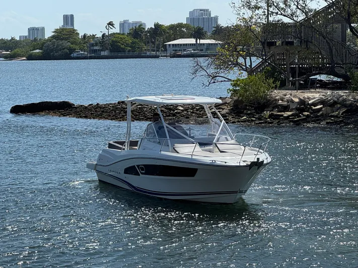  Yacht Photos Pics 2020 Jeanneau Leader 9.0 WA boat cruising on a scenic waterway with city skyline.