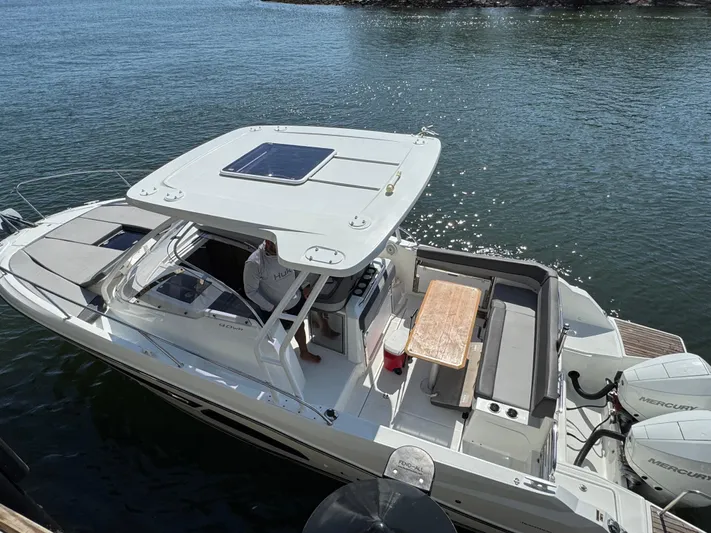  Yacht Photos Pics 2020 Jeanneau Leader 9.0 WA boat docked on calm water, featuring spacious deck and seating.