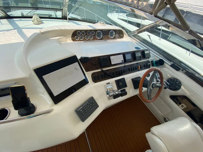  Yacht Photos Pics 1997 Sea Ray 450 Sundancer helm with wood accents and modern navigation equipment.