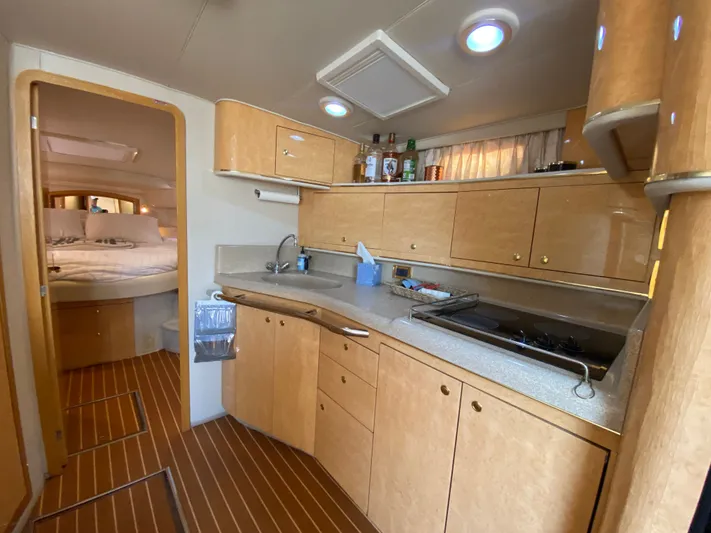  Yacht Photos Pics Interior of 1997 Sea Ray 450 Sundancer yacht with modern kitchen and cozy bedroom.