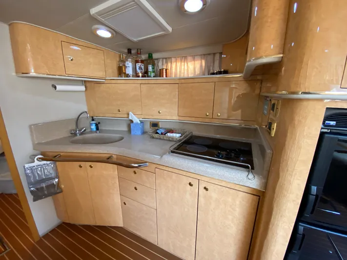  Yacht Photos Pics 1997 Sea Ray 450 Sundancer yacht kitchen with wooden cabinets and modern appliances.