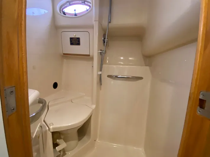  Yacht Photos Pics 1997 Sea Ray 450 Sundancer bathroom with shower, toilet, and porthole window.