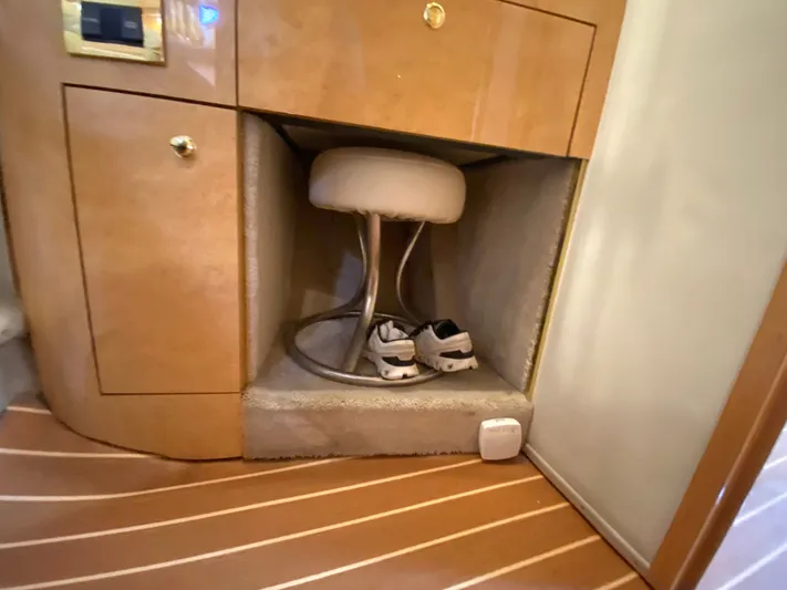  Yacht Photos Pics 1997 Sea Ray 450 Sundancer interior with wooden cabinetry and shoes stored under a stool.