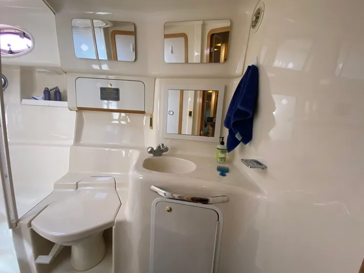  Yacht Photos Pics Bathroom interior of 1997 Sea Ray 450 Sundancer yacht, featuring sink, toilet, and mirror.