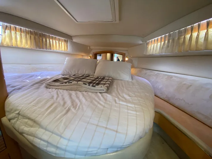  Yacht Photos Pics Cozy cabin interior of 1997 Sea Ray 450 Sundancer with comfortable bedding and soft lighting.