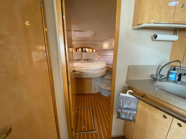  Yacht Photos Pics Interior of 1997 Sea Ray 450 Sundancer yacht, featuring cozy bedroom and compact kitchenette.