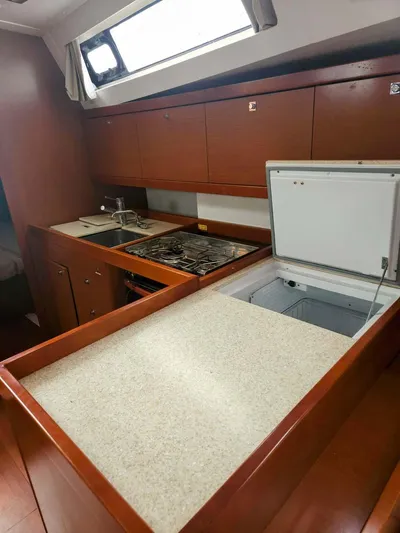 Far Star Yacht Photos Pics 2012 Beneteau Oceanis 41 yacht kitchen with wood cabinetry and modern appliances.