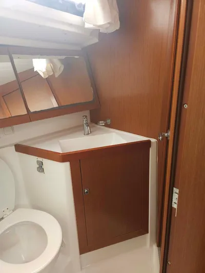 Far Star Yacht Photos Pics 2012 Beneteau Oceanis 41 yacht bathroom with wood cabinetry and modern fixtures.
