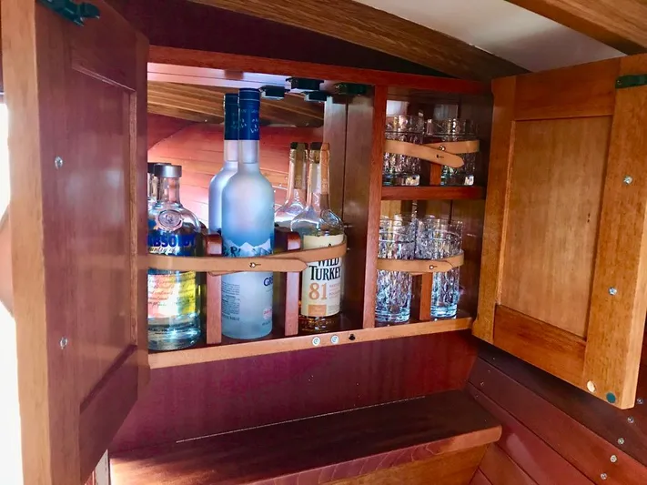  Yacht Photos Pics Wooden cabinet with liquor bottles and glasses in a 2020 Custom Windlea Runabout.