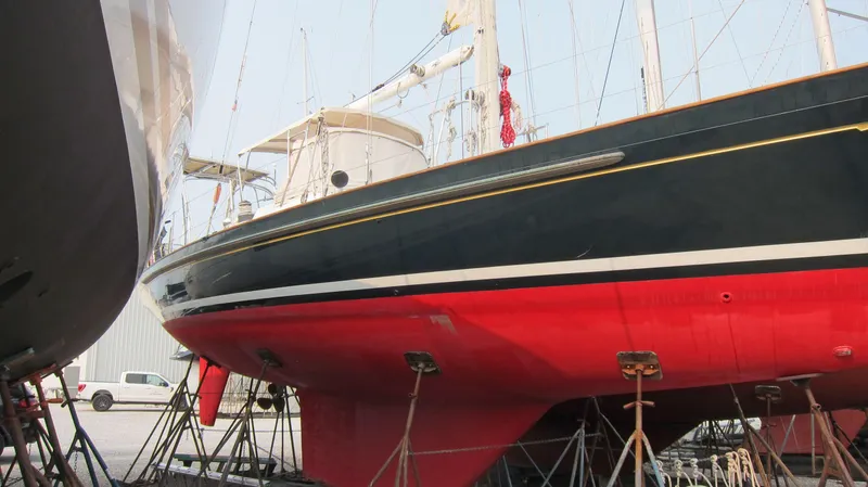 Ghost Yacht Photos Pics Sailboat on stands, Passport 47 model, 1985, with red hull and black upper section.