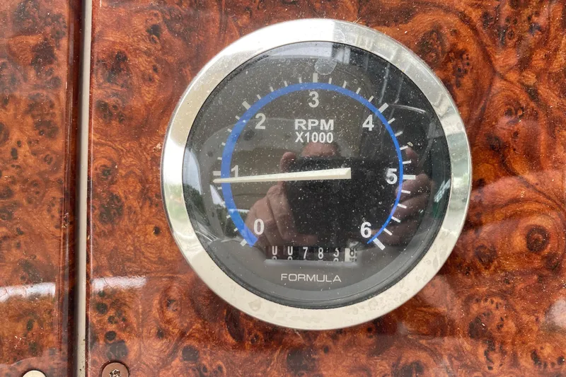  Yacht Photos Pics Tachometer of 2004 Formula 370ss boat, displaying RPM on a wood-patterned dashboard.