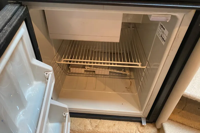  Yacht Photos Pics Empty mini fridge with open door, showing wire shelf and interior compartments.