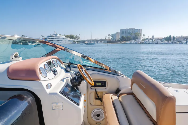Dream Chaser Yacht Photos Pics 2006 Chris-Craft Corsair 36 boat interior with steering wheel, dashboard, and waterfront view.