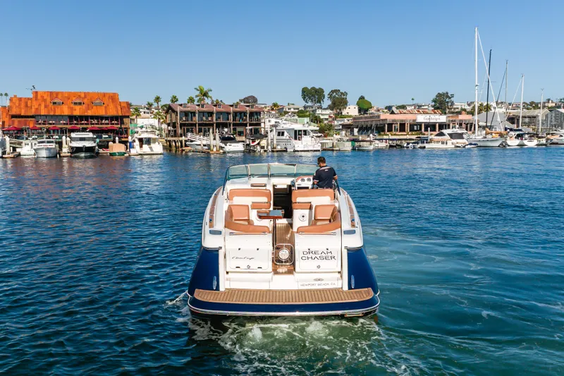 Dream Chaser Yacht Photos Pics 2006 Chris-Craft Corsair 36 boat cruising in a marina, surrounded by waterfront buildings.