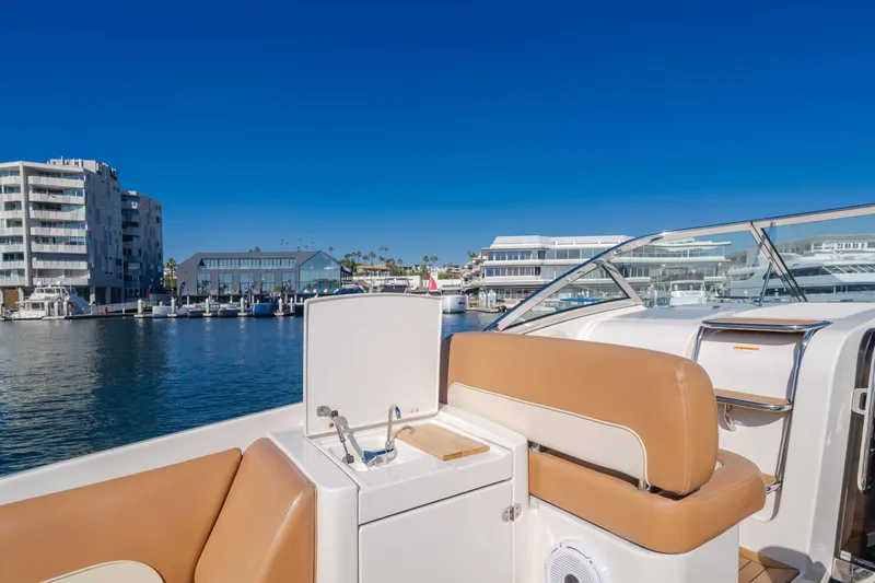 Dream Chaser Yacht Photos Pics 2006 Chris-Craft Corsair 36 yacht interior with marina view, featuring tan seating and clear skies.