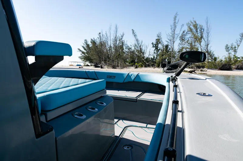  Yacht Photos Pics 2022 Costa Custom Boats 264 interior with blue seating, near a sandy beach.