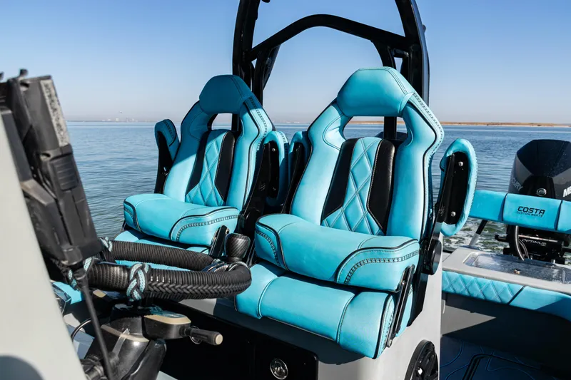  Yacht Photos Pics Luxurious blue seats on a 2022 Costa Custom Boats 264, with a scenic water backdrop.