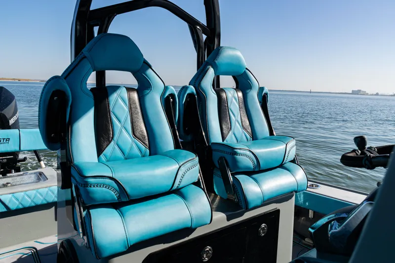  Yacht Photos Pics Luxurious blue seats on a 2022 Costa Custom Boats 264, overlooking serene waters.